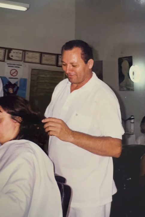 Fundador do Elmo's Cabeleireiros atendendo cliente nos primeiros anos