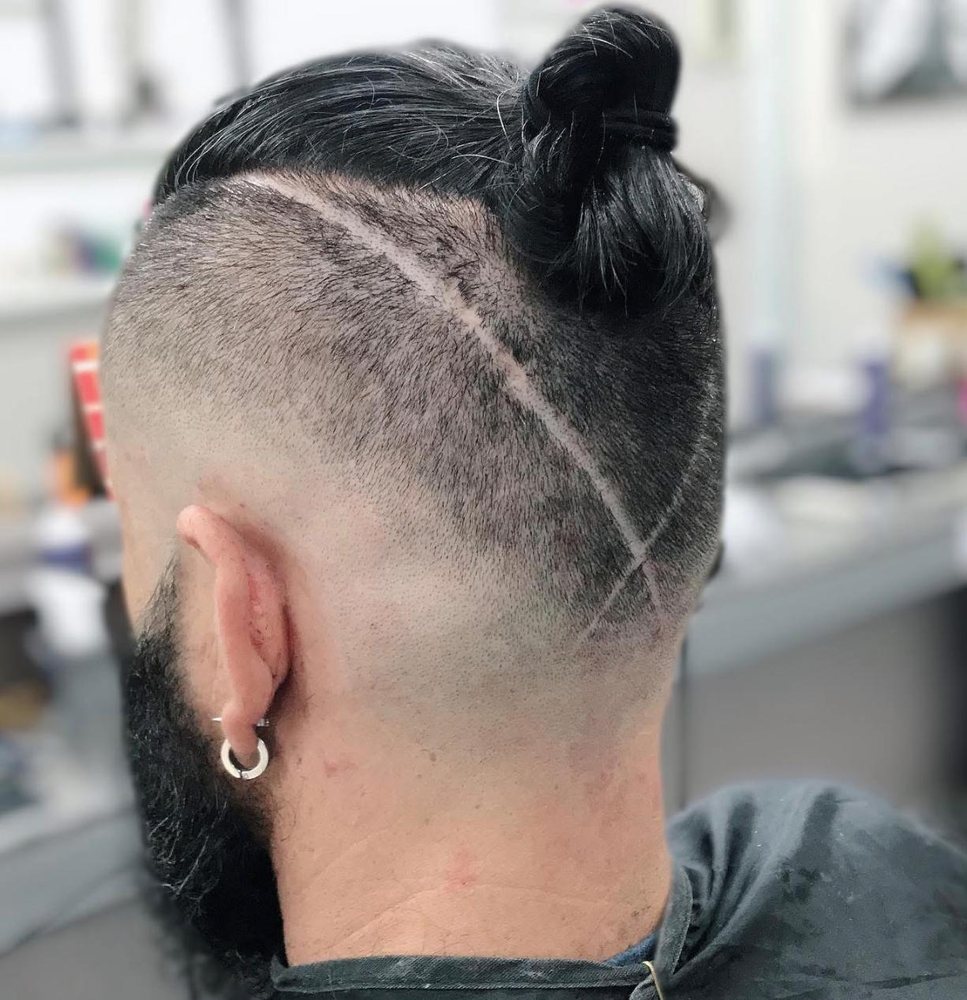 Corte masculino com coque e desenho na lateral no Elmo's Cabeleireiros Valinhos